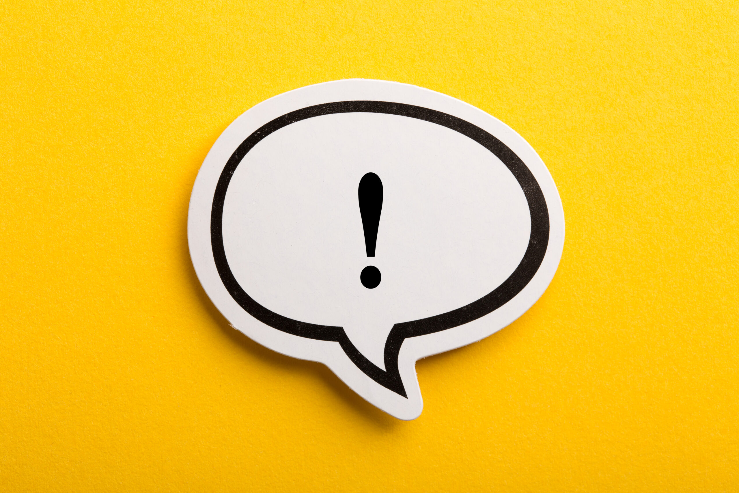 Exclamation point in a speech bubble on a yellow background