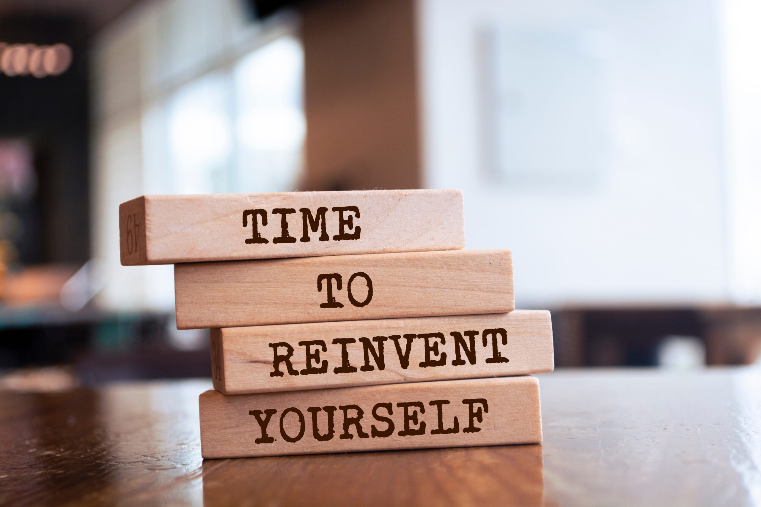 Wooden blocks on a table that read, "Time to reinvent yourself"