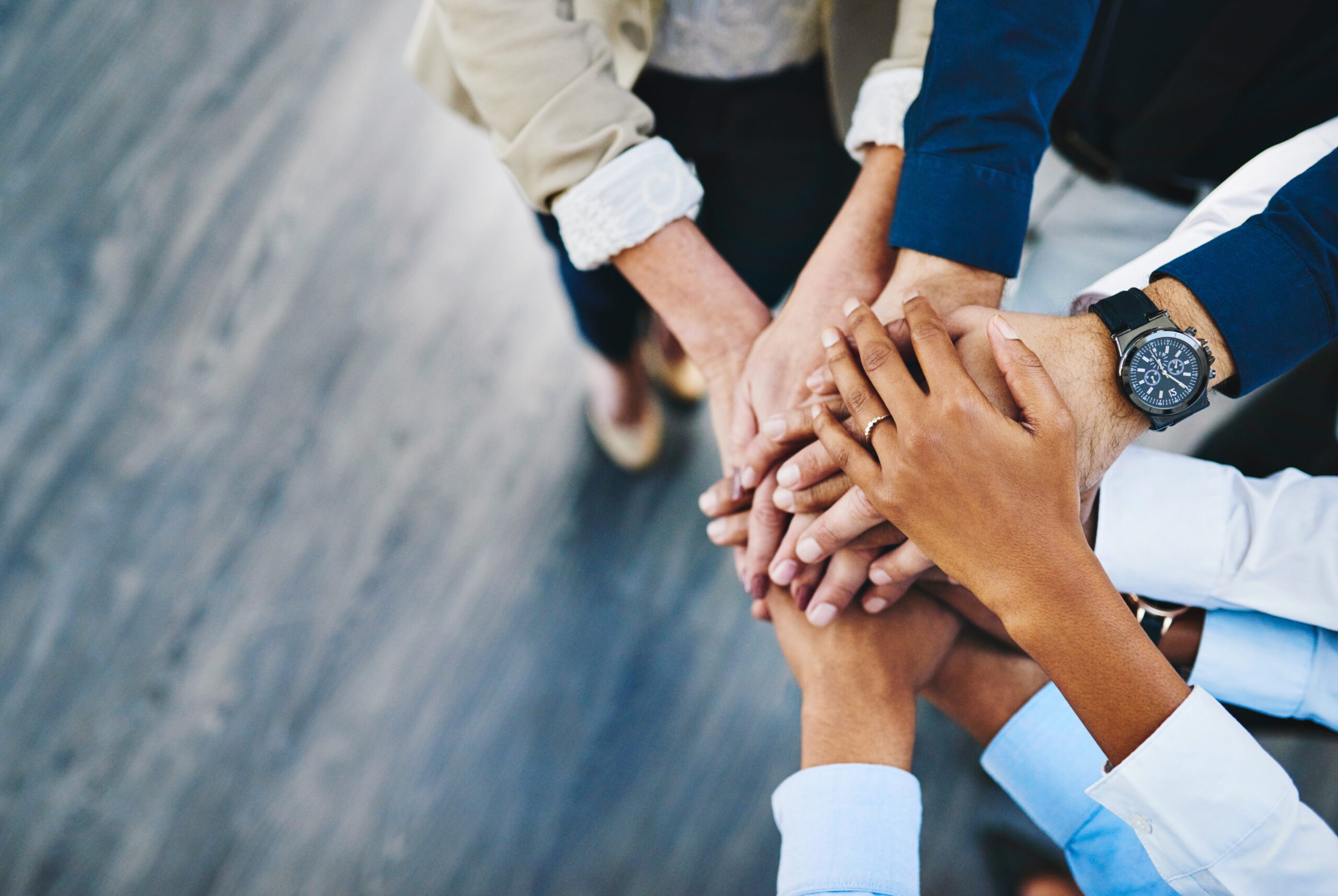Several business people piling their hands over each other in a show of collaboration