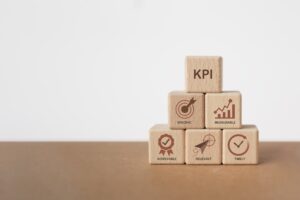 Six building blocks in a tower, with KPI on top and blocks with the five elements of SMART goals in the others