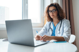 Female veterinarian working at laptop