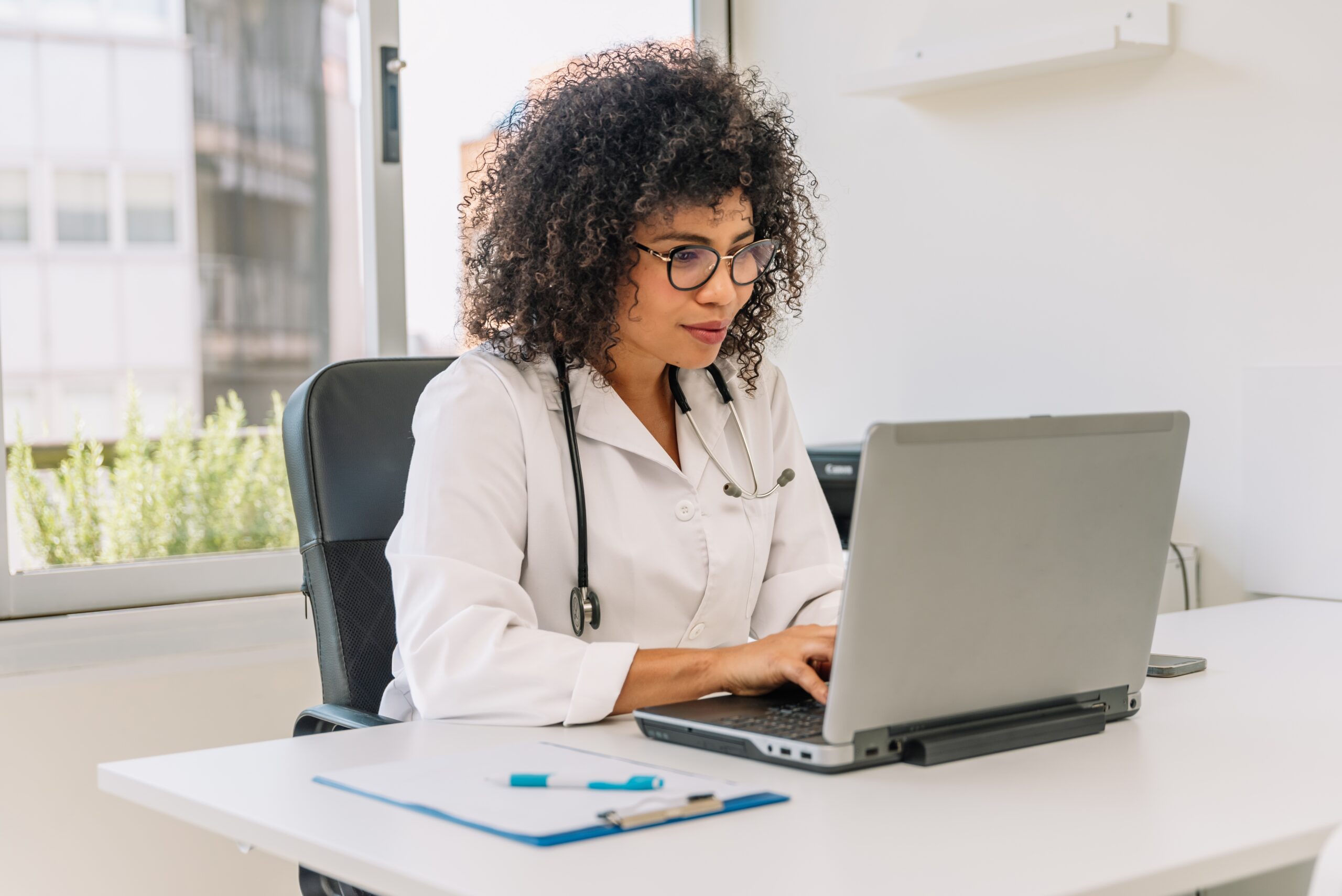 Female private veterinary practice owner at a desk typing on a laptop